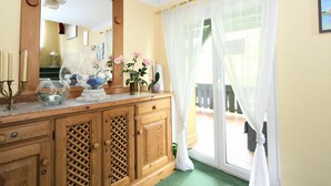 A room with a wooden cabinet, a mirror, and a window with sheer curtains. - Beautiful apartment for 6 people with WIFI, TV, terrace and panoramic view (Hippach)