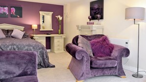 Une chambre avec deux lits, une coiffeuse et une chaise.