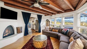 A spacious living room with a large sectional sofa, a fireplace, and a view of the mountains. - Heavenly Mountain Views-Close to Plaza, Hot tub, Ski & Pickleball, Upscale home (Santa Fe)