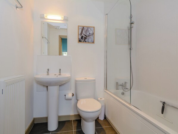 A bathroom with a white sink, toilet, and a glass-enclosed shower. - 2 bedroom accommodation in Nr Wells (Nr Wells)