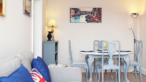 Ein Essbereich mit Tisch und Stühlen, einer Lampe, einem Globus und einem Bild an der Wand.