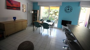 Un comedor con una mesa y sillas, un armario de madera y una pared azul.