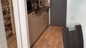 Ett modernt kök med träskåp, en inbyggd ugn och en kaffebryggare.