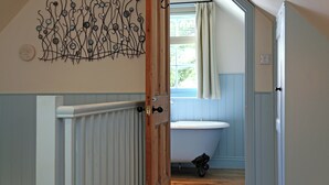 A bathroom with a white sink, a wooden door, and a decorative wall piece. - 1 bedroom accommodation in Tunbridge Wells (Tunbridge Wells)