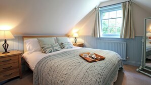 A cozy bedroom with a large bed, two bedside tables with lamps, a window with curtains, and a tray with a cup and saucer on the bed. - 1 bedroom accommodation in Tunbridge Wells (Tunbridge Wells)