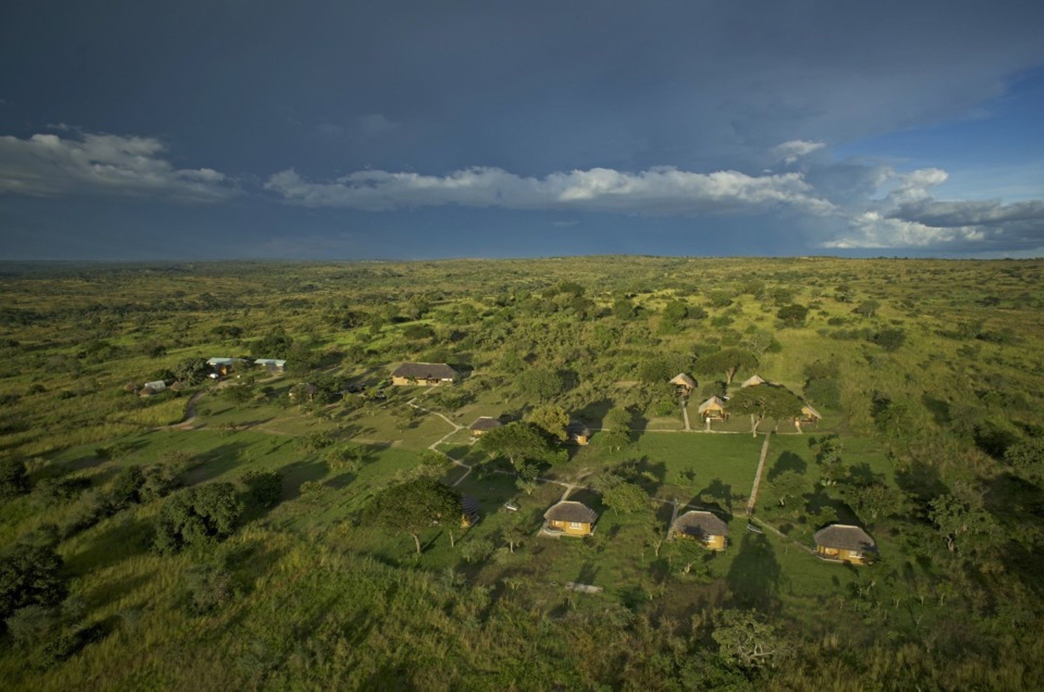 An aerial view of a rural area with scattered houses and a large open field.