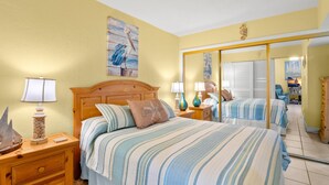 Una camera d'albergo con un letto, comodini, lampade, uno specchio e un quadro appeso al muro.