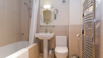 Ein Badezimmer mit Badewanne, Waschbecken, Toilette und Handtuchhalter.