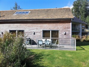 A wooden house with a balcony, a window, and a door.