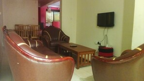 Relax in this cozy living space with a sofa set, coffee table, and mounted TV.