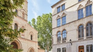 A courtyard with a building featuring arched windows and a door. - Hotel de l'Abbaye (Lyon)