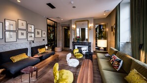 A modern living room with a fireplace, sofas, and a coffee table. - Hotel de l'Abbaye (Lyon)
