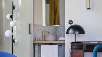 A modern bathroom with a vanity, mirror, and towel rack.