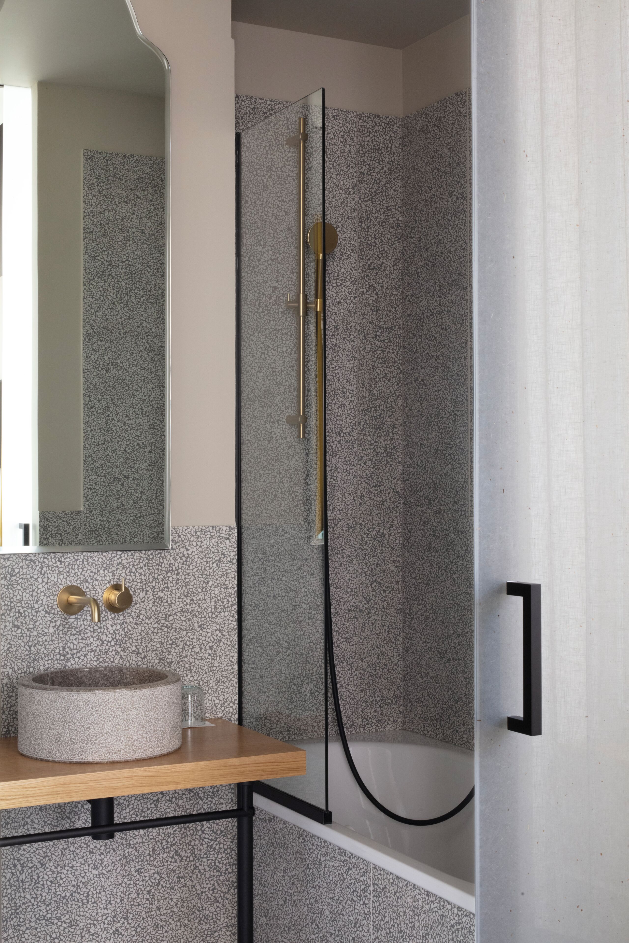 A bathroom with a freestanding bathtub, a round sink, and a shower enclosure.