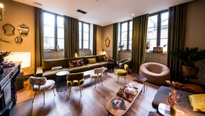 A modern living room with a sofa, chairs, a coffee table, and a dining table. - Hotel de l'Abbaye (Lyon)