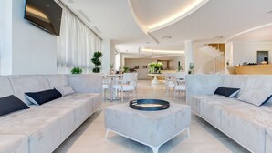 Ein modernes Wohnzimmer mit zwei Sofas, einem Couchtisch und einem an der Wand befestigten Fernseher.