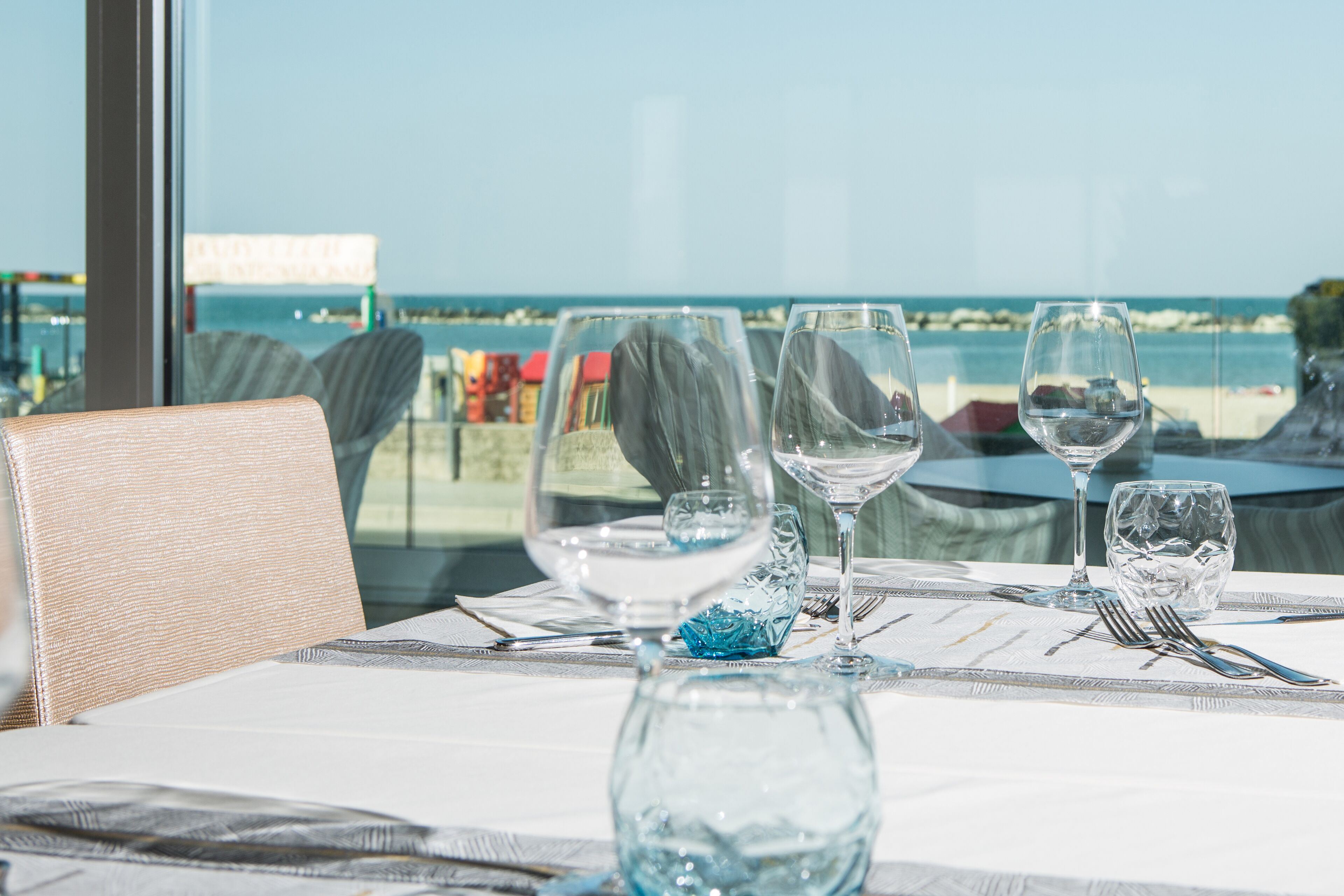 A table set for dining with a view of the ocean.
