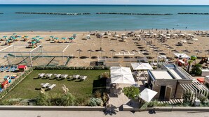 Ein Strandresort mit Liegestühlen, Sonnenschirmen und einem Poolbereich.