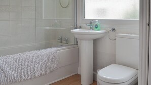 A bathroom with a bathtub, a sink, and a toilet. - 2 bedroom accommodation in Benllech (Benllech)