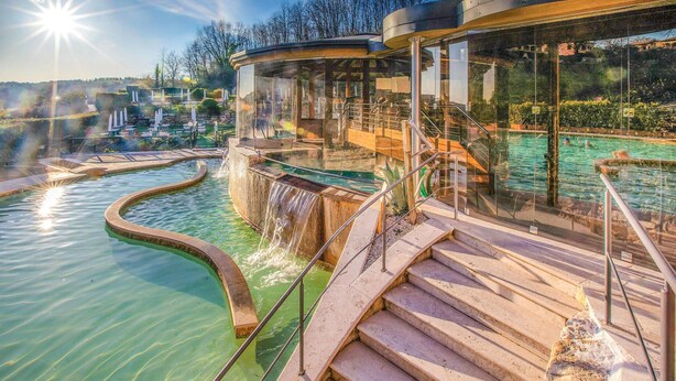 A spa area with a pool, a glass-enclosed structure, and a staircase leading to a deck. - Anticheterme / Trilocale (Sorano GR)