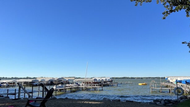 Ein Strand mit einem Liegestuhl und einer Anlegestelle für Boote.