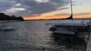 Ein Yachthafen mit vertäuten Booten, bewölkter Himmel und Sonnenuntergang.