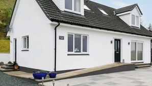 Une maison à deux étages, avec une façade blanche, un toit noir et une enseigne indiquant « EILEAN VIEW ».