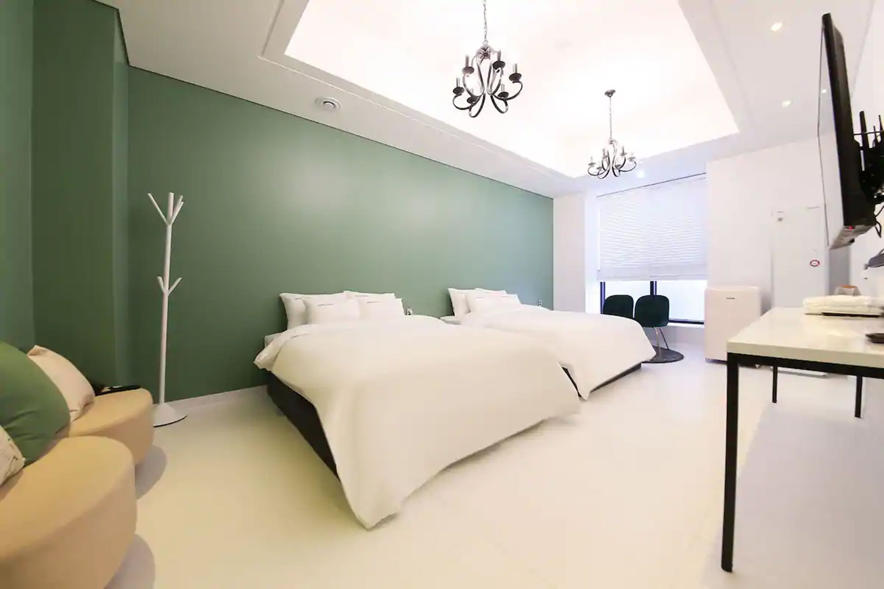 Un dormitorio moderno con tragaluz, una cama, un escritorio y una silla.