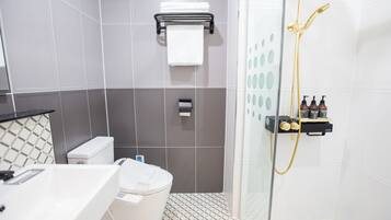 A modern bathroom with a toilet, sink, and shower.