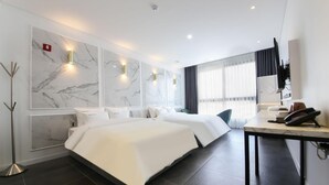 A modern hotel room with two beds, marble wall decor, and a desk with a telephone. - Hotel RAUM (Suncheon)