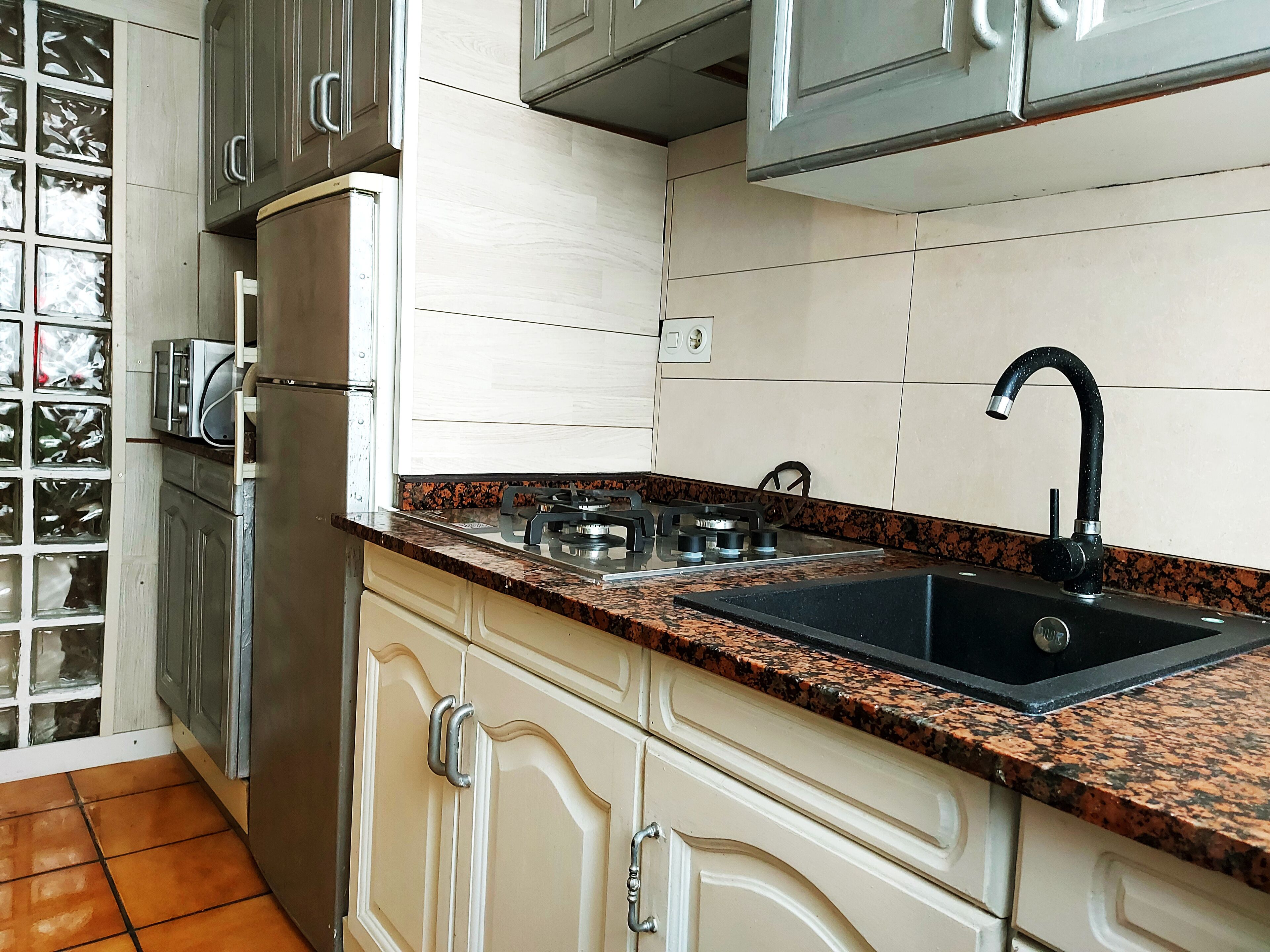 Een koelkast, een microgolfoven, een kookplaat, een waterkoker