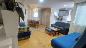 A living room with a sofa, a dining table with chairs, a kitchen area with cabinets, and a large window. - APARTMENT CLOE FUNCINAL CENTER ALICANTE FOR FAMILIES UP TO 8PERS. (Alacant)