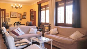 Ein Wohnzimmer mit zwei Sofas, einem Couchtisch und einer Essecke mit Stühlen und einem Tisch.