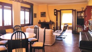 Ein Essbereich mit rundem Tisch und Stühlen, einer Couch und einem Kamin.