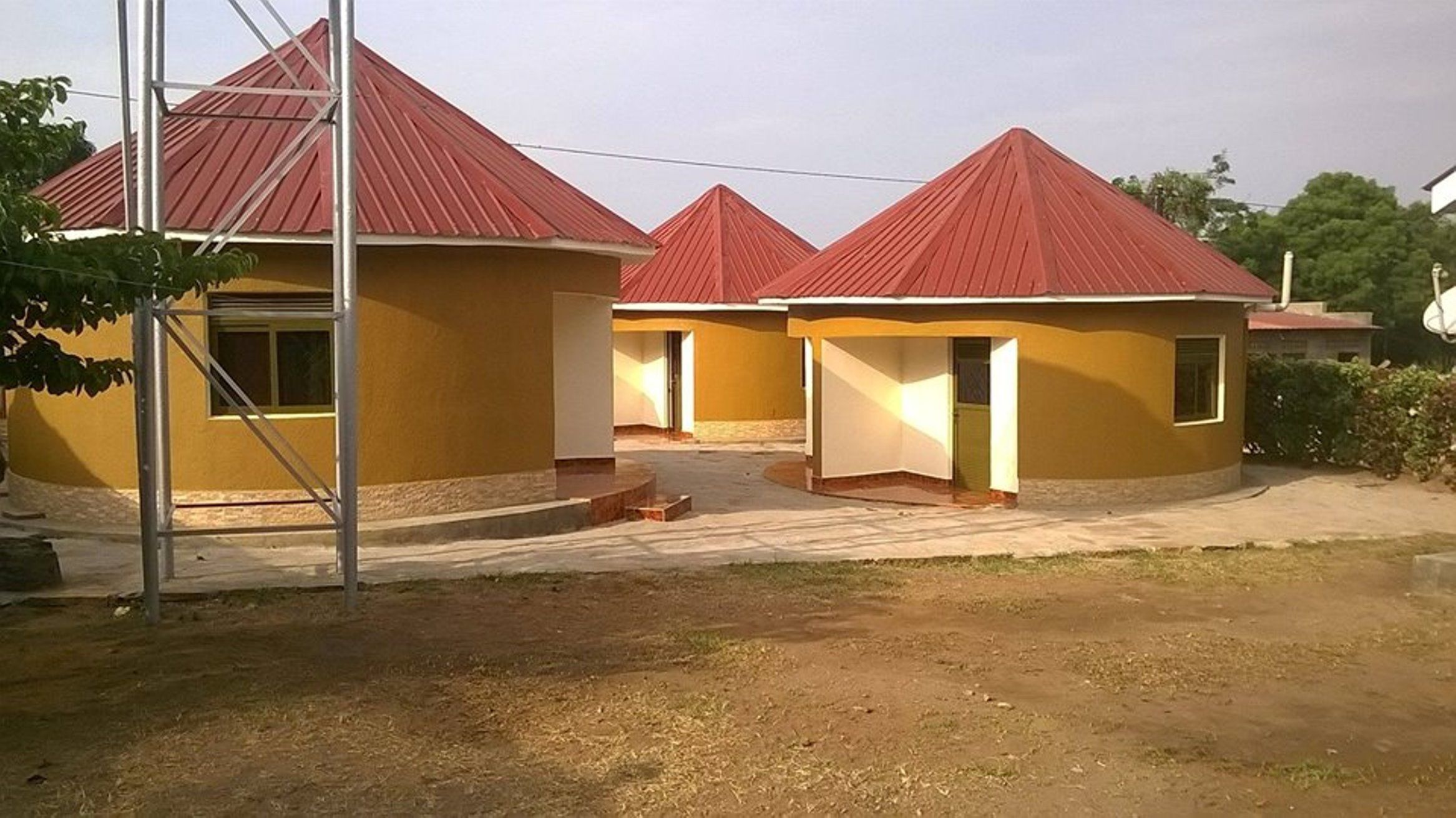Un edificio con tres estructuras de techo amarillo, cada una con una entrada pequeña y un ventanal visible.