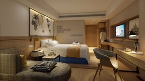 Una habitación de hotel moderna con una cama grande, un escritorio, una silla y un televisor.
