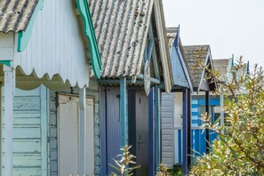 Eine Reihe von Ferienhäusern am Meer mit Wellblechdächern und Holztüren.