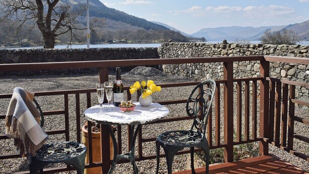 A terrace with a table set for two, overlooking a scenic mountain landscape. - 1 bedroom accommodation in St Fillans, near Crieff (St Fillans, near Crieff)
