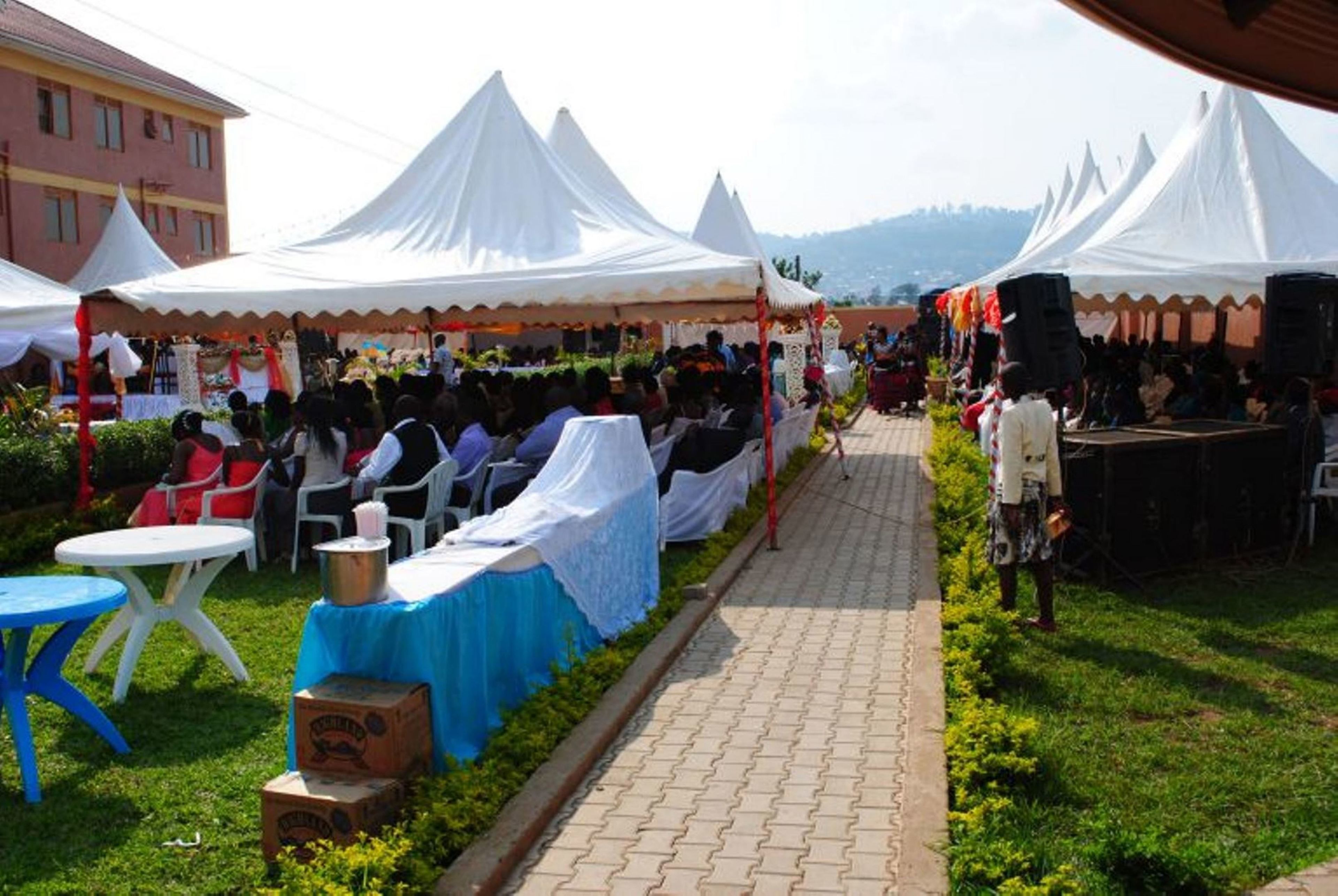 Evento al aire libre con carpas blancas y mesas dispuestas para los asistentes.