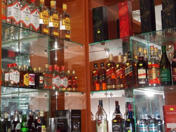 Un bar con estantes llenos de botellas de licores y cajas.