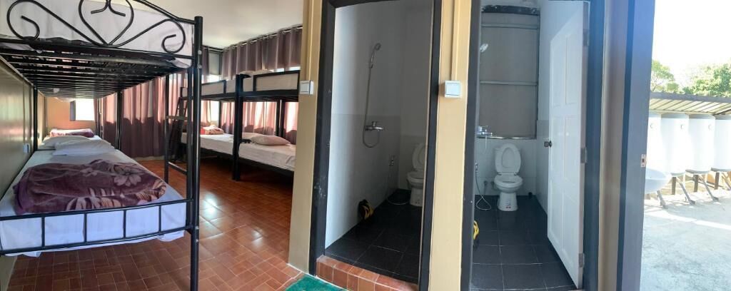 A room with bunk beds, a bathroom with a shower, and a toilet.