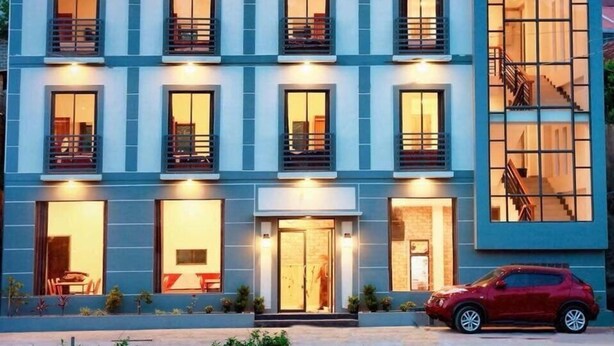 A hotel with a modern design, featuring a prominent 'Sky Hotel' sign, multiple balconies, and a staircase leading to an upper level. - Sky Motel Kalaw (Kalaw)