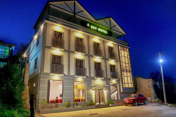 Ein Hotel namens "Sky Motel" mit modernem Design, mehreren Balkonen und einem gut beleuchteten Eingang.