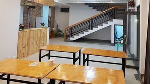 A modern interior with wooden ceiling panels, a staircase, and a reception area. - Sky Motel Kalaw (Kalaw)