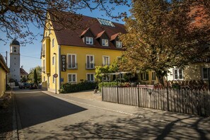 A yellow building with a sign reading "HOTEL" and a bell tower. - Neumaiers Hirsch Gasthof & Landhotel (Weissenhorn)