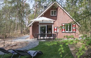 A brick house with a patio, outdoor seating, and a garden. - 3 bedroom amazing home in Ommen (Ommen)