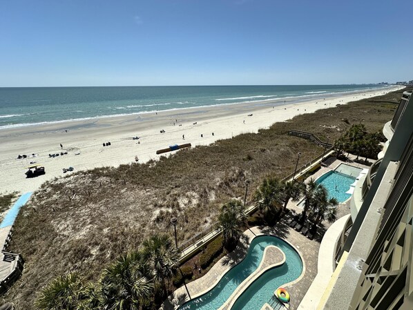 Enjoy a beachfront view from the balcony overlooking the pool and sandy beach.
