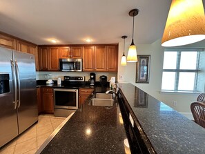 Enjoy cooking in this well-equipped kitchen with a refrigerator, microwave, and oven, along with a sink and countertop.