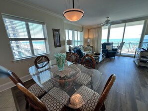 A spacious living area with a dining table, chairs, and a view of the ocean. - MVG 704 3 BEDROOM 3 BATH OCEANFRONT CORNER (North Myrtle Beach)