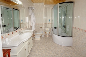 A bathroom with a large sink, toilet, and shower. - Bozok Hotel (Astana)